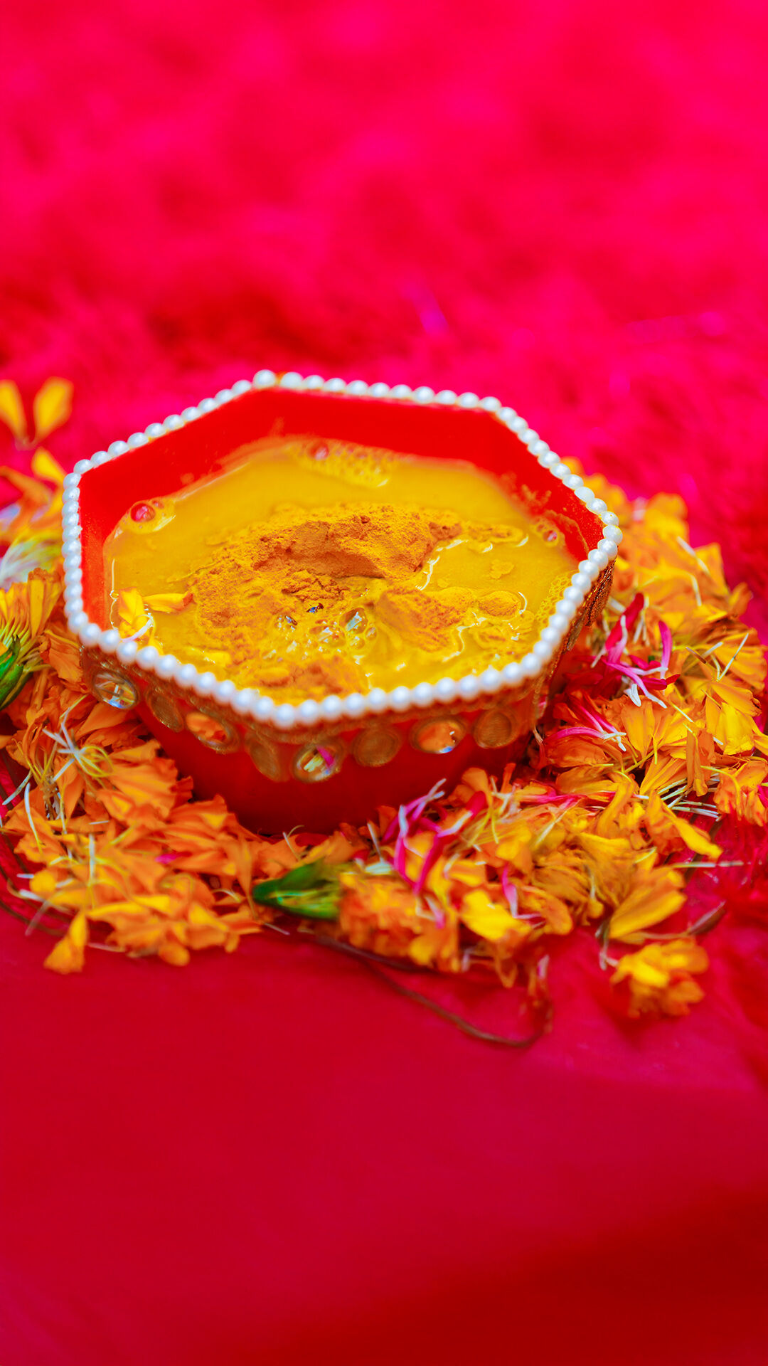 A beautifully decorated bowl filled with Haldi, perfect for a traditional Indian pre-wedding ritual